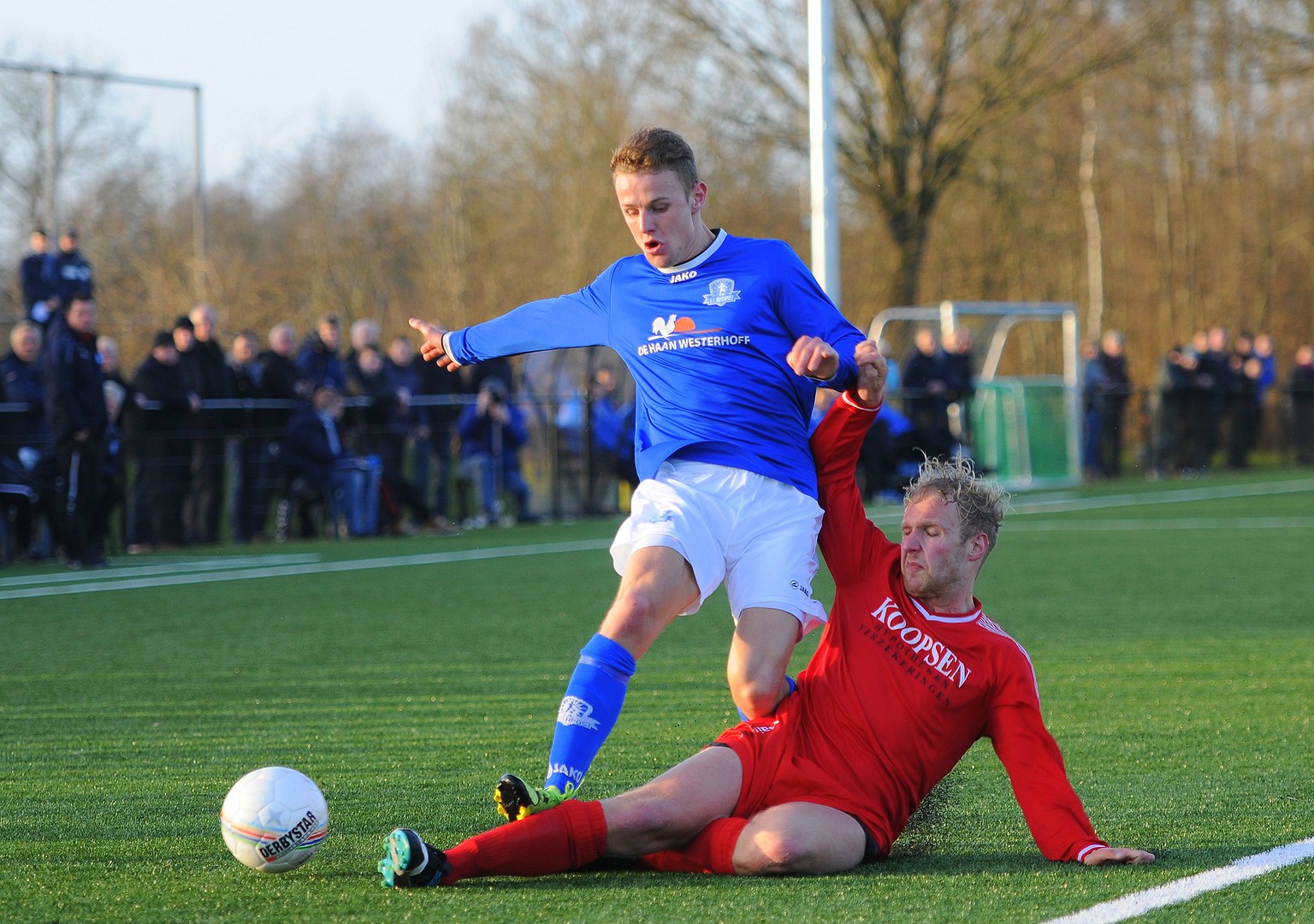 Opkomende verdediger Wim de Vries wordt van de bal gegleden.